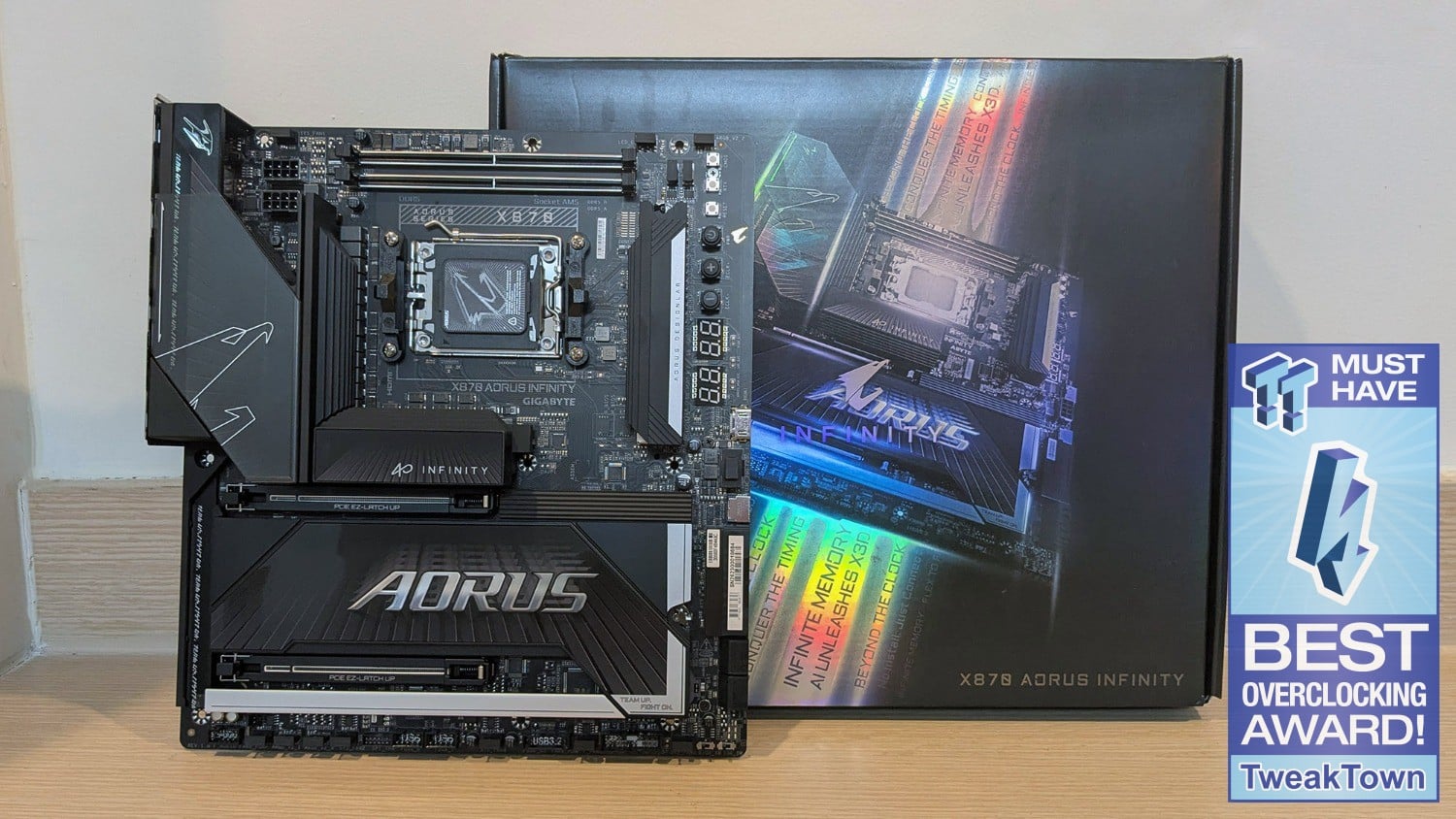 GIGABYTE X870 AORUS Infinity motherboard displayed in front of its box, with a TweakTown overclocking award badge at the right.