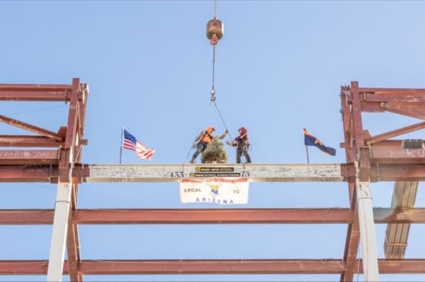 TSMC workers placing the final roof structure beam (source: TSMC)