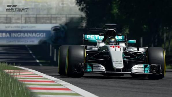 A silver Mercedes Formula 1 car with Petronas branding drives toward the camera beside a red-and-white curb in Gran Turismo Sport.